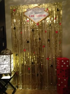 the las vegas sign is on display in front of a gold curtain and red dices