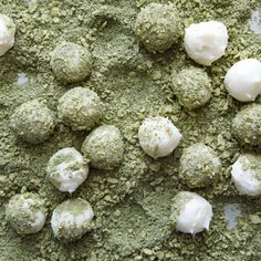 there are several balls of green stuff on the counter top, and one is covered in powdered sugar