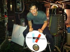 a man sitting on top of a white drum