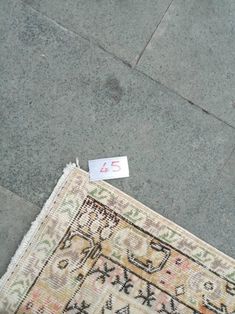 a piece of cloth on the ground next to a rug with a price tag in it