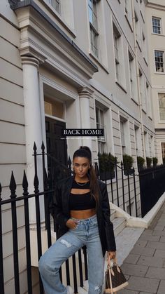 a woman sitting on a bench in front of a building