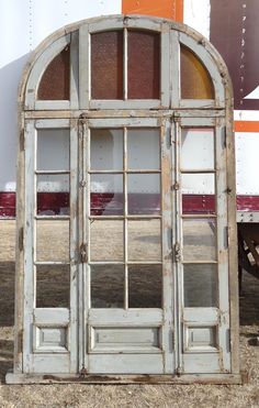 an old white window sitting on the side of a road