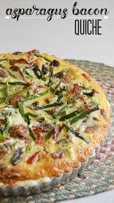 a quiche with asparagus and bacon on it sitting on top of a table