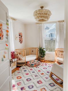 a baby's room with a crib, rocking chair and rug in it