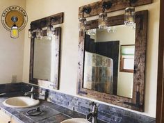 two sinks in a bathroom with mirrors and lights on the wall above them, along with an old fashioned light fixture