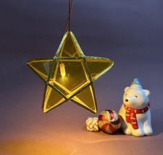 an ornament shaped like a star next to a teddy bear