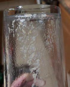 a glass filled with water and ice on top of a table