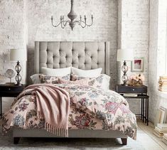 a bedroom with a bed, nightstands and chandelier