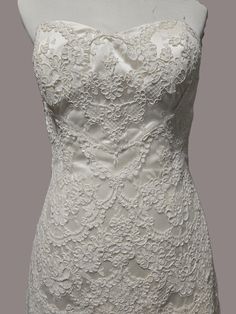 a white wedding dress is displayed on a mannequin