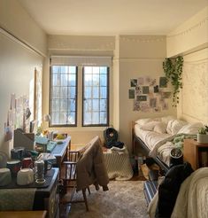 a bedroom with two twin beds and desks in front of the window, surrounded by other furniture