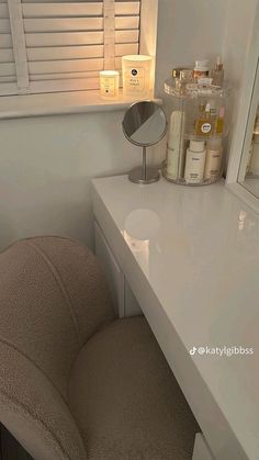 a white counter top sitting next to a mirror in a bathroom with candles on it