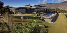 an aerial view of a house with a pool in the yard and mountains in the background