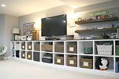 a living room filled with lots of furniture and shelves next to a flat screen tv