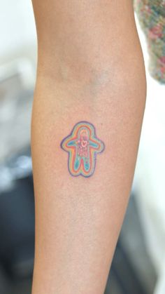 a person with a tattoo on their leg that has an image of a hamsa