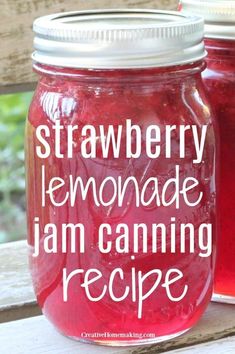 two mason jars filled with strawberry lemonade jam sitting on top of a wooden table