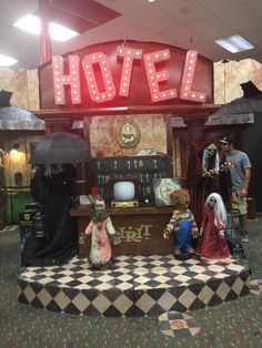 several people standing in front of a sign that says hotel on top of a checkerboard floor