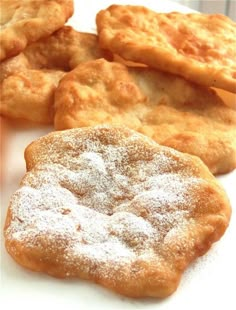 several pastries on a white plate with powdered sugar