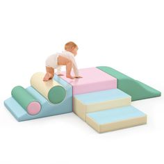 a baby crawling on top of a set of blocks with different colors and shapes in front of it