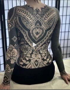 the back of a woman with tattoos on her body