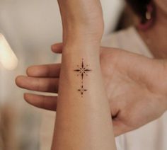 a woman's arm with a small star tattoo on it