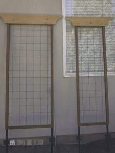 two windows with wooden slats in front of them on the side of a building