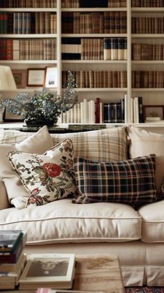 a living room filled with lots of furniture and bookshelves full of books on top of them