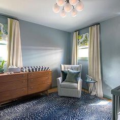 a baby's room with blue walls and carpeted flooring is pictured in this image