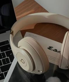 a pair of headphones sitting on top of a table next to a laptop computer