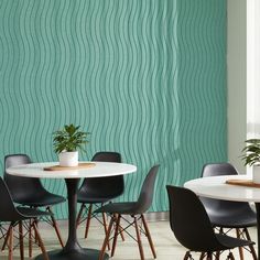 a dining room table with chairs and a potted plant on top of it in front of a green wall