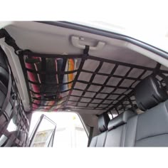 the interior of a vehicle with several items in it's cargo area and luggage hanging from the ceiling