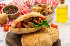 two pita breads stacked on top of each other with meat and vegetables in the background