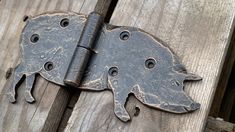 an old metal pig door hinge on a wooden fence