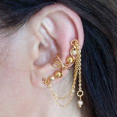 Gold Bridesmaid Cuff/No Piercing/Elegant Ear Wrap Beautiful 24 K Gold plated ear cuff with  gold plated beads and a dangly gold plated chain that can be worn differently on each ear.  The ear cuff  is adjustable  and easily fitted to any ear. Comfortable to wear. This listing is for one ear cuff which can be worn on either ear. Thanks for visiting. See more Ear Cuffs here: https://www.etsy.com/uk/shop/AlteredElegance?section_id=20952583 Or see our Minimalist Range here: https://www.etsy.com/uk/s Ear Cuff Chain, Tragus Ring, Tragus Hoop, Gold Bridesmaids, Gold Waves, Bridal Wrap, Minimal Earrings, Fake Piercing, Gold Ear Cuff