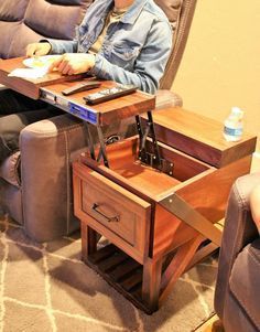 a man sitting at a table with a remote control in his hand and a laptop on it