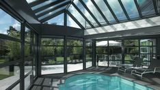 an indoor swimming pool surrounded by glass walls