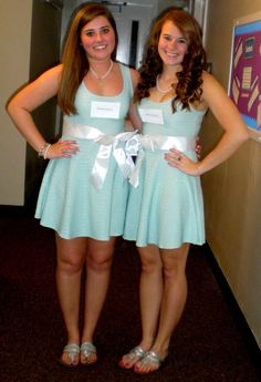 two women standing next to each other in dresses