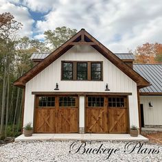 a white house with two brown garage doors