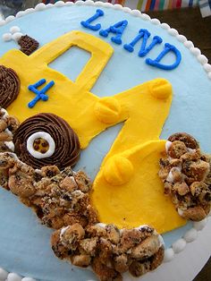 a blue and yellow birthday cake with the number 4 on it's side, decorated like a construction vehicle