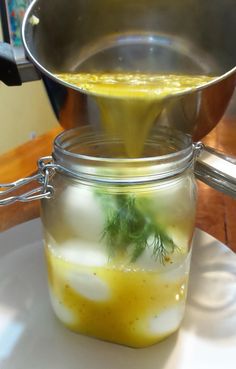 a glass jar filled with liquid sitting on top of a white plate