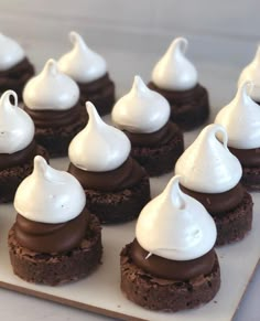 chocolate desserts with white frosting are arranged on a cutting board