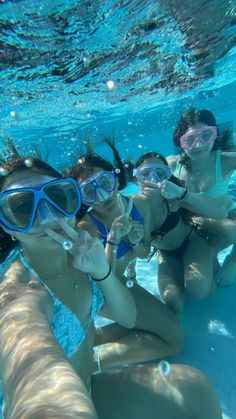 three girls wearing goggles and snorkels in the water