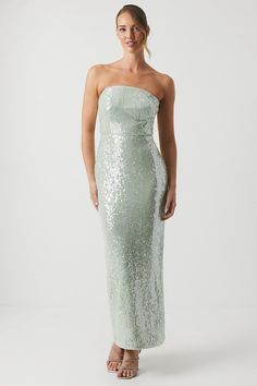 a woman wearing a strapless dress with sequins