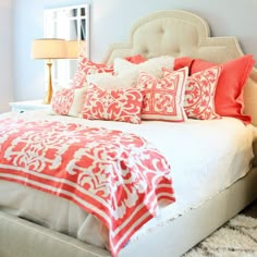 a bed with red and white pillows in a bedroom