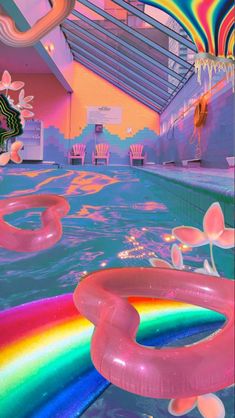 an indoor pool with rainbow colored water and chairs