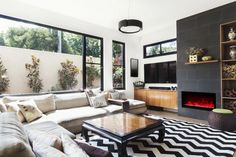 a living room filled with furniture and a fire place in the middle of it's wall