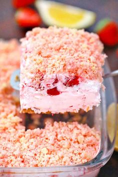 strawberry shortcakes are stacked on top of each other in a glass dish with strawberries around the edges