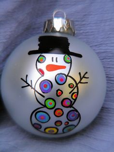 a glass ornament with a snowman painted on it