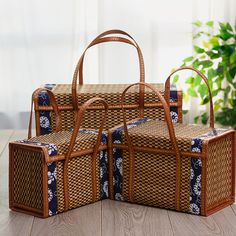 three pieces of woven luggage sitting on top of a wooden floor next to a potted plant