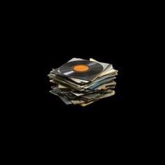 a stack of old records sitting on top of each other in front of a black background