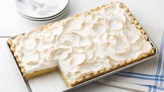 a pie sitting on top of a metal pan covered in frosting next to a fork